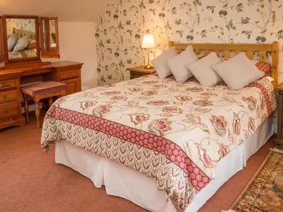 a bedroom with a bed and a desk and a mirror at Uk35716 - North Cottage in Teviothead