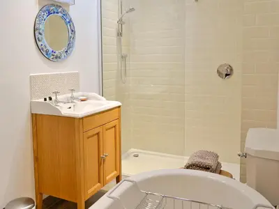 a bathroom with a tub and a sink and a bath tub at The Barn in Greystoke