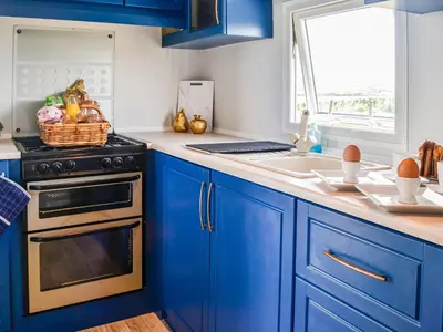 a blue kitchen with a stove and a sink at The Seaview Retreat - Uk35883 in Broughton Mains