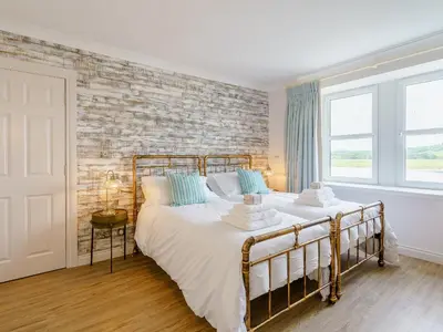 a bedroom with a bed and a brick wall at Erriff At Caelaverock in Glencaple