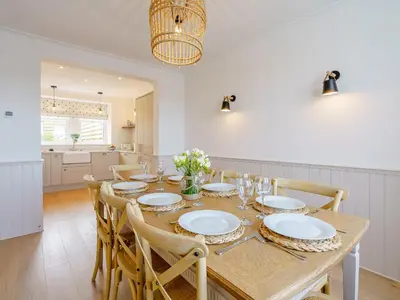 a dining room with a wooden table and chairs at Erriff At Caelaverock in Glencaple
