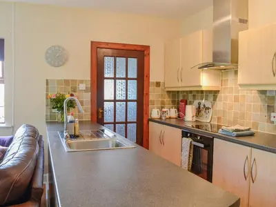a kitchen with a sink and a counter top at Lime Tree Cottage in Drumpark