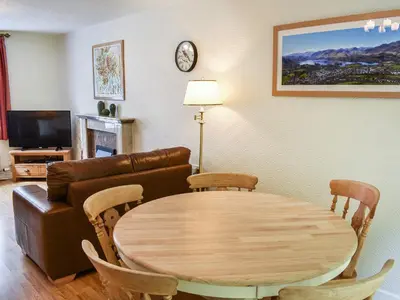 a living room with a table and a couch at Jane Eyre Cottage in Keswick