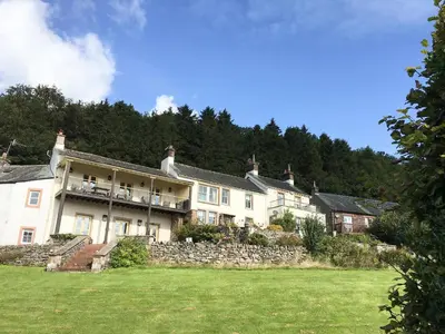 a large house on a hill with a grass field at Mell Fell in Watermillock