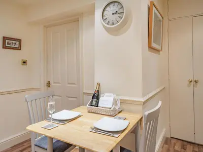 a dining room table with a clock on the wall at Mell Fell in Watermillock