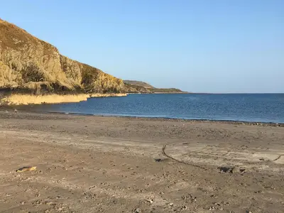 a sandy beach with the ocean in the background at Oor Wee Hoose in Whithorn
