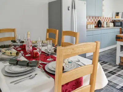 a dining room table with a red and white table cloth at Oor Wee Hoose in Whithorn