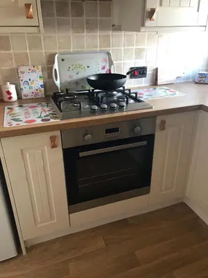 a kitchen with a stove with a pan on it at West View Cottage in Seaside Village of Allonby Cumbria in Allonby