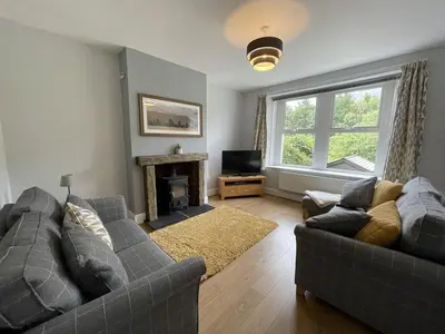 a living room with two couches and a fireplace at Glenderamackin Cottage in Threlkeld