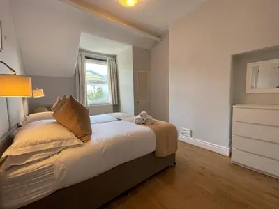 a bedroom with a bed with a teddy bear on it at Glenderamackin Cottage in Threlkeld