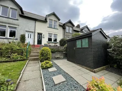 a house with a black shed in the yard at Glenderamackin Cottage in Threlkeld