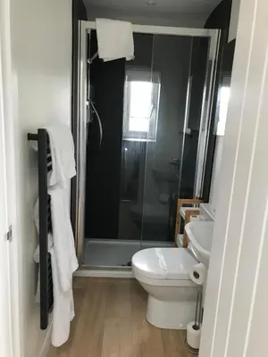 a bathroom with a shower and a toilet and a sink at The Nook at Claremont House CA12 4LT in Keswick