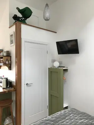 a bedroom with a white door and a green cabinet at The Nook at Claremont House CA12 4LT in Keswick