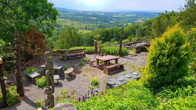 a picnic table and benches in a garden with a view at Scafell Cottage on The Big 