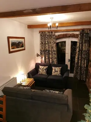 a living room with a couch and a table at Rainors farm cottage in Gosforth