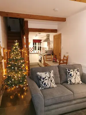 a living room with a christmas tree and a couch at Rainors farm cottage in Gosforth