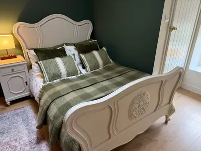 a bed in a bedroom with a green wall at 1-Bed studio Apartment nr Cockermouth in Cockermouth