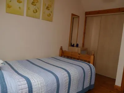 a bedroom with a bed with a blue and white blanket at Belmont Cottage in Dumfries