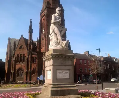 a statue of a man standing in front of a building at Belmont Cottage in Dumfries