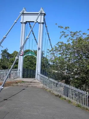 a white bridge with a gate and a fence at Belmont Cottage in Dumfries