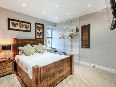 a bedroom with a large wooden bed in a room at The Barn Owl - Uk36217 in Bowness-on-Solway