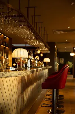 a bar with a red stool in front of a counter at Dundonald Links in Dreghorn