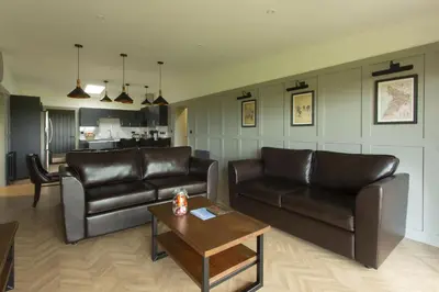 a living room with two leather couches and a coffee table at Dundonald Links in Dreghorn