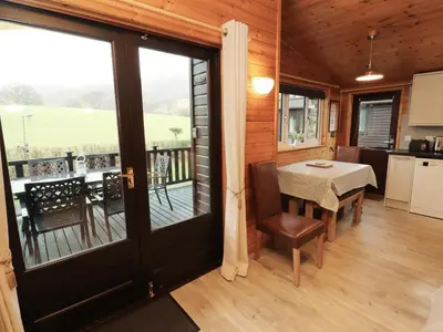 a kitchen and dining room with a table and a balcony at The Fold in Keswick