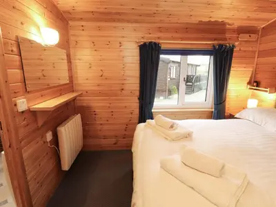 a bedroom with two beds in a wooden cabin at The Fold in Keswick