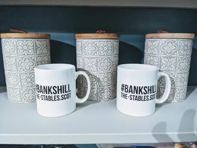 four coffee mugs are sitting on a shelf at The Stables - Bankshill in Lockerbie