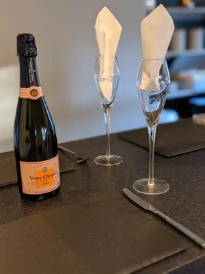 a bottle of wine and two wine glasses on a table at The Stables - Bankshill in Lockerbie