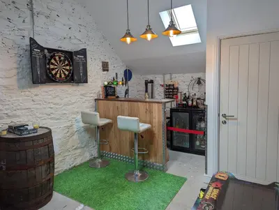 a bar with a dart board on the wall at The Stables - Bankshill in Lockerbie