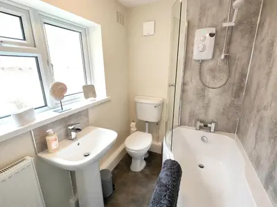a bathroom with a sink and a toilet and a shower at Douglas House, near Hospital, attractive and comfy 2 bedroom House with enclosed yard to rear in Carlisle