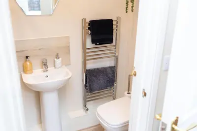 a small bathroom with a sink and a toilet at Russell House, Large townhouse spacious and modern with ground floor bedroom and shower room and free parking in Harraby