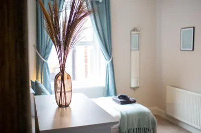 a vase with feathers in it sitting on a table at Russell House, Large townhouse spacious and modern with ground floor bedroom and shower room and free parking in Harraby