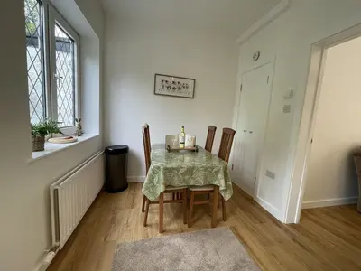 a dining room with a table and chairs and a window at Fairbank in Keswick