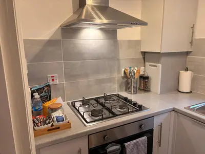a kitchen with a stove top oven in a kitchen at Kinfirth Apartment in Ayr