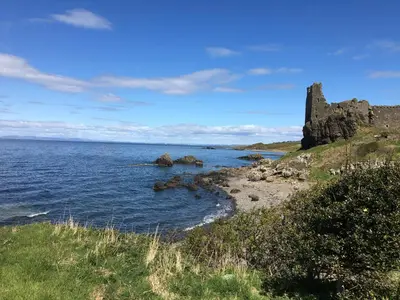 a castle on the shore of a body of water at Kinfirth Apartment in Ayr