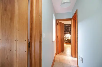 a hallway with wooden doors and a room with a hallway at Camerton Hall Cottage in Workington