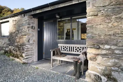 a bench sitting outside of a stone building at Grasmere Cottage with Stunnng Views by LetMeStay in Ambleside