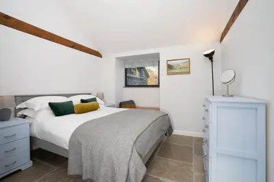 a white bedroom with a bed and a dresser at Grasmere Cottage with Stunnng Views by LetMeStay in Ambleside