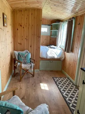 a small room with a bed and a chair at Fauld O Wheat Shepherds Hut , Loch Ken ,Off Grid in Castle Douglas