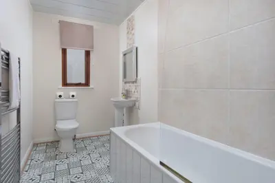 a bathroom with a tub and a toilet and a sink at Prestwick Central - Donnini Apartments in Prestwick