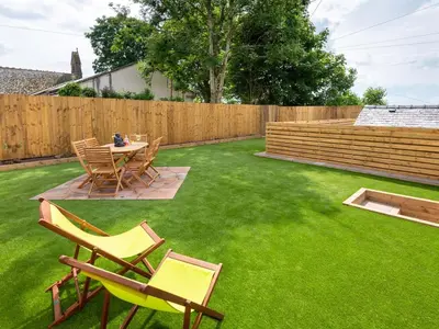 a backyard with a table and chairs on grass at Highgate in Kirklinton