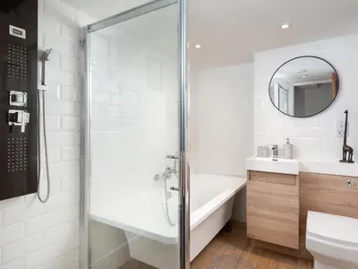 a bathroom with a shower and a tub and a sink at Highgate in Kirklinton