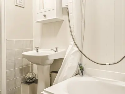 a white bathroom with a sink and a shower at Catbells in Arlecdon