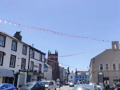 a busy city street with cars parked on the street at Catbells in Arlecdon