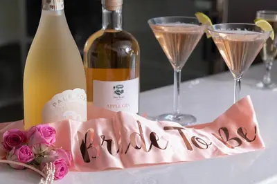 a table with a bottle of wine and a pink napkin at Big Pink House in Mealsgate