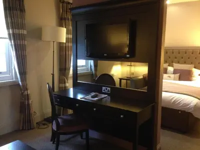 a hotel room with a desk with a mirror at Dumfries Arms Hotel in Cumnock