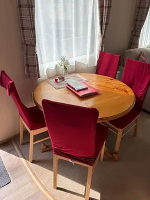 a wooden table with four red chairs around it at Woodpecker lodge, Camelot Holiday Park, CA6 5SZ in Carlisle
